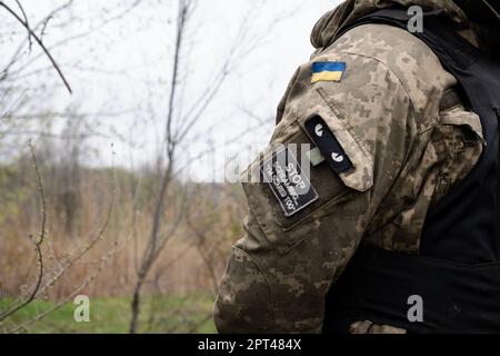 Bakhmut, Ukraine. 15th Apr, 2023. A patch written 'stop screaming ''˜I'm scared too''' is seen on a Ukrainian soldier's army uniform, alongside a Ukrainian flag in the Ukrainian position near Bakhmut. Ukrainian armed force is fighting intensely in Bakhmut and the surrounding area as Russian forces are getting ever closer to taking the eastern city of Ukraine. The battle of Bakhmut is now known as 'the bloodiest'' and 'one of the longest fight'', it has become one of the most significant fights in the war between Ukraine and Russia. (Credit Image: © Ashley Chan/SOPA Images via ZU Stock Photo