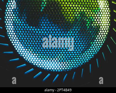 Colorful led lights of computer fan shines through the protective grid. illumination glows in the dark. abstract futuristic background Stock Photo