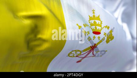 Close-up view of the Vatican City national flag waving in the wind. The Vatican City State is the smallest sovereign state in the world. Fabric textur Stock Photo