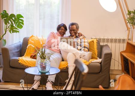 Senior couple checking the tablet together to share and see something interesting. Concept: senior couple, retirement, entertainment Stock Photo