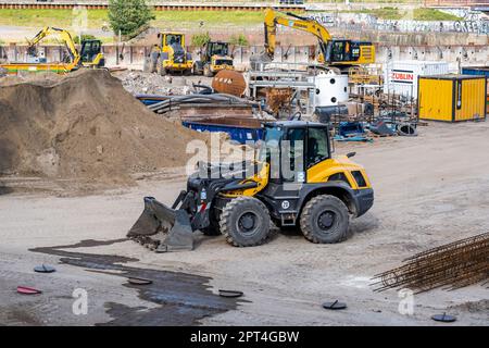 Hamburg, Germany - 07 05 2022:Construction site in Hamburg with a wheel loader in the foreground and various construction machines in the background Stock Photo