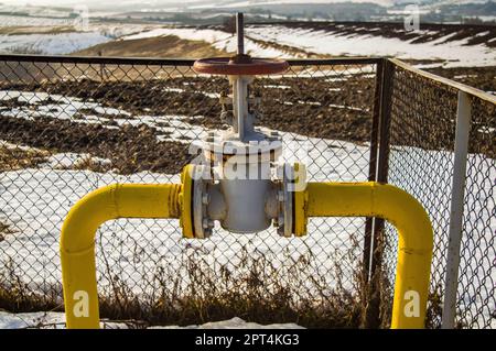 Gas pipe with valve for opening and closing the supply. Natural gas pipeline. Adjustment valve. North. White snow in winter. Flow. Industrial equipmen Stock Photo