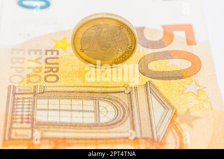 One Euro coin on the 50 Euro note banknote. Stock Photo