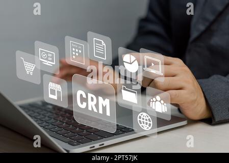 Hand typing on laptop concept. Icons CRM Customer Relationship Management business on virtual screen. Stock Photo