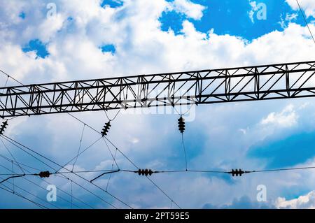 Iron mast with high voltage electric power wires of the railway. Railway. Transport infrastructure. Electric wires for powering trains. Industrial equ Stock Photo