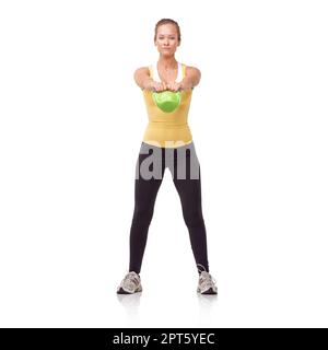 Engaging her glutes. A beautiful blonde woman performing a two-handed kettlebell swing Stock Photo