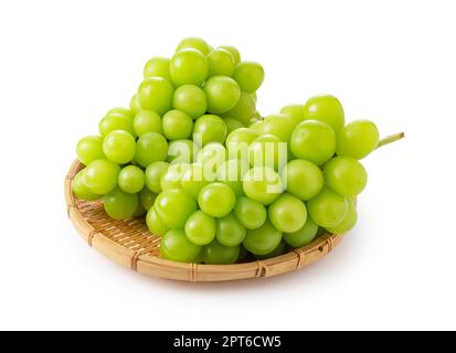 Shine Muscat in a bamboo colander on a white background. White grapes. Japanese grapes. Stock Photo