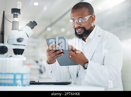 Analysing the sample extensively. a male scientist using a digital tablet while working in a lab Stock Photo