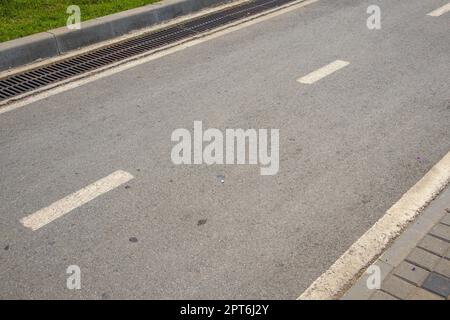 An intermittent lane marking line and the direction of traffic on an asphalt road with a copy of the space. Stock Photo