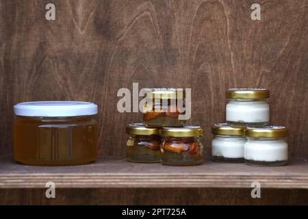 Nuts and honey in small jars on shelf Stock Photo