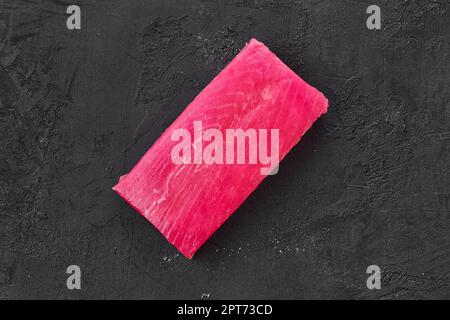 Raw frozen tuna fillet on black background Stock Photo