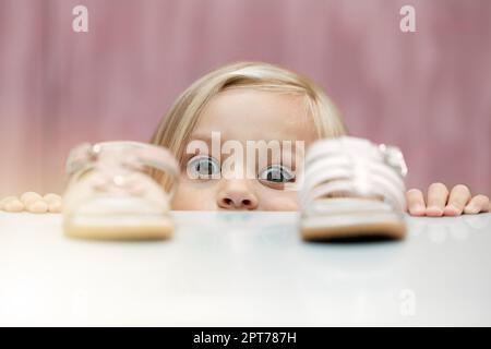 Girl, shoes and shopping with a child customer deciding between footwear for fashion, style or consumerism. Children, retail and option with a kid loo Stock Photo