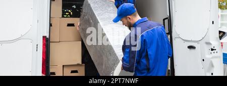 Furniture Mover Unloading Truck. Relocation Delivery Load Stock Photo