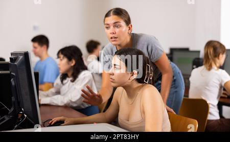 Teacher and schoolgirl using computer in science center Stock Photo - Alamy