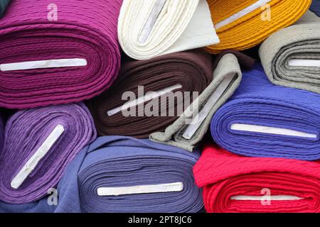 Samples of cloth and fabrics in different colors found at a fabrics market. Stock Photo