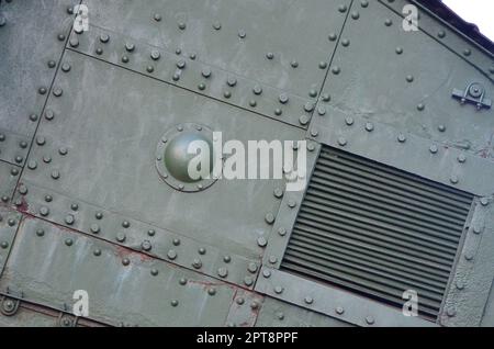 Texture of tank side wall, made of metal and reinforced with a multitude of bolts and rivets. Image of covering of a combat vehicle from the Second Wo Stock Photo