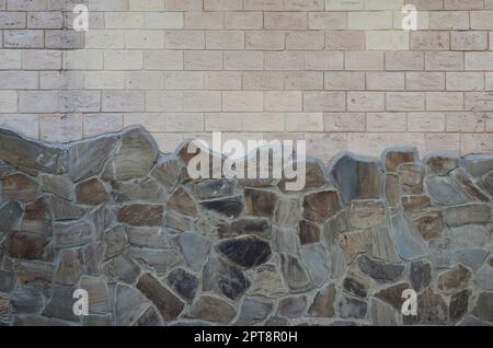 Rustic old beige white brick wall background and worn foundation with shabby brown stones Stock Photo