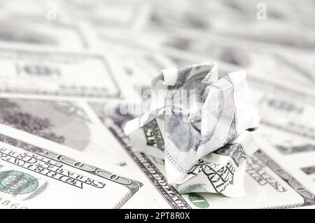 Crumpled dollar bill of the United States lies on the set of smooth money bills. Concept of unreasonable waste of money Stock Photo