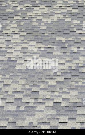 Flexible shingles of bitumen roofing surface. Background mosaic texture of flat roof tiles with bituminous coating Stock Photo