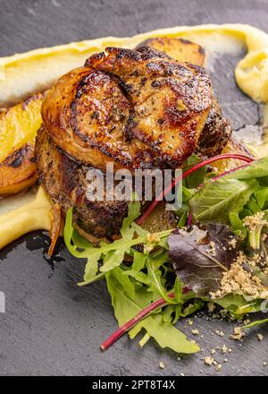 Succulent thick juicy portions of grilled fillet steak served with greens Stock Photo
