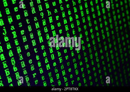 Macro shot of a glitch on the monitor of an office computer. The concept of introducing a virus into a personal data keeper. Stream of random green sy Stock Photo