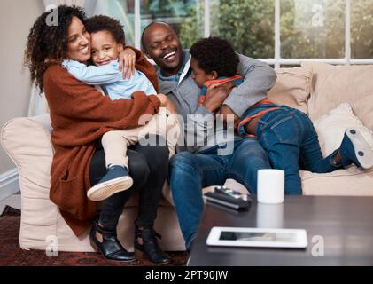 Big hugs for all. a happy family relaxing on a sofa at home Stock Photo