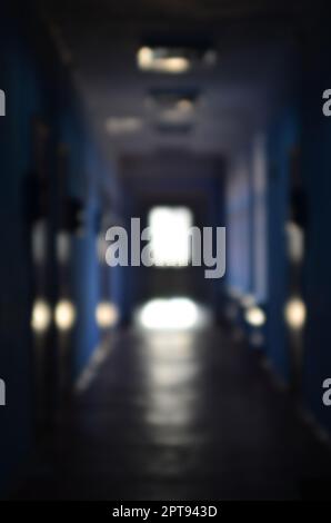 The blurred image of gloomy corridor of a neglected public building. Defocused picture of a public space in a poor residential high-rise building Stock Photo