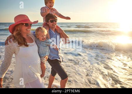 Summers are for strolling on the beach. a young family enjoying a day at the beach. Stock Photo