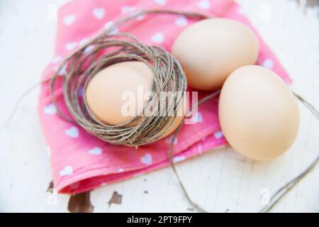 three eggs on the table on a rose napkin. Stock Photo
