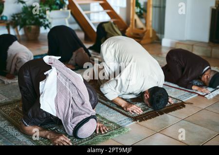 Giving thanks for all that we have. a group of muslim family members praying together Stock Photo