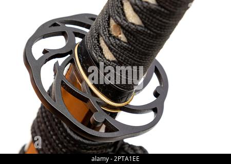 Close up the  'Tsuba' - hand guard of Japanese sword made by steel isolated in white background. The sword handle wrapped by black silk cord. Selectiv Stock Photo