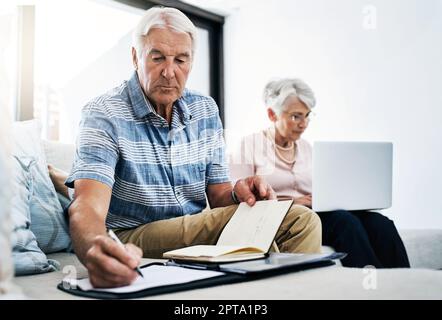 The cost of living is serious business. a senior couple going through their paperwork together at home. Stock Photo