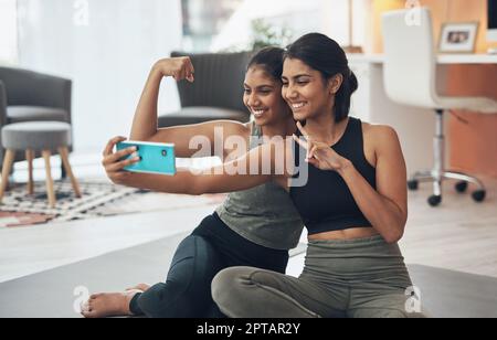 Were always in the mood for a selfie after a workout. two young women  taking a selfie while sitting at home in exercise clothes Stock Photo -  Alamy
