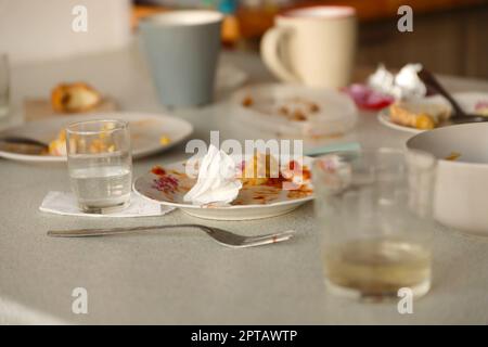 Empty dirty plates with spoons and forks on the table after meal. Banquet ending concept. Unwashed dishes ready to cleaning Stock Photo