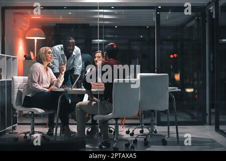 All night productivity. colleagues having a meeting during a late night in a modern office. Stock Photo