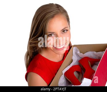 She keeps up to date with the latest fashion trends. High angle shot of an attractive young woman holding a box of new high heels against a white back Stock Photo