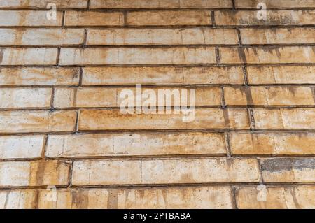 The texture of the wall of concrete blocks with traces of rust. Block concrete wall. Rust streaks. Industrial construction. View from bottom to top. A Stock Photo
