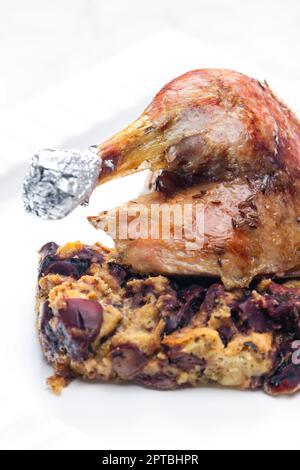 bake poultry leg served with stuffing with red beans Stock Photo