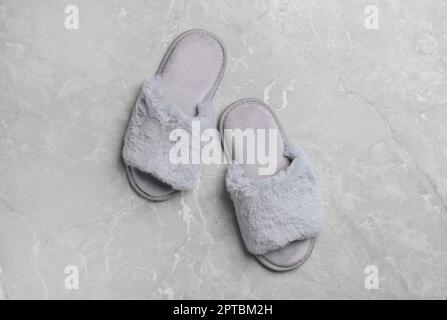 Pair of soft slippers on grey marble floor top view Stock Photo