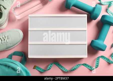 Blank letter board, shoes and sports equipment on pink background, flat lay. Mockup for design Stock Photo