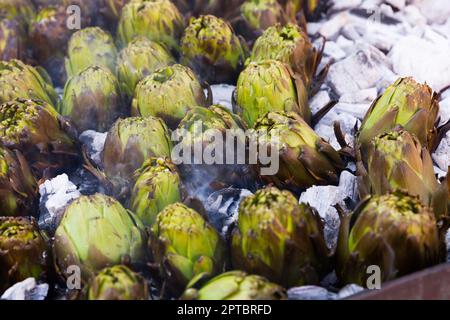 Artichokes being cooked on charcoals Stock Photo