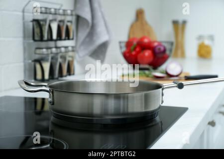 Empty frying pan on induction stove in kitchen Stock Photo