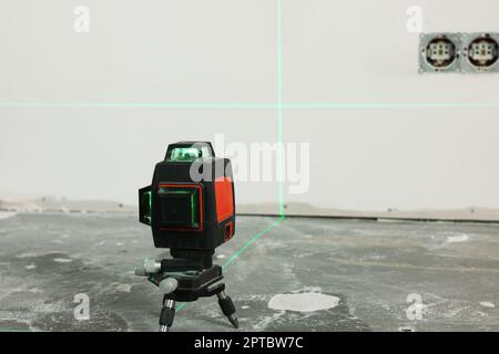Laser level on floor near electrical sockets Stock Photo