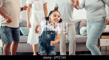 Happy girl with family dancing in living room while playing, having fun and enjoy bonding quality time together. Happy family love, connection and fre Stock Photo