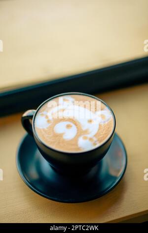 Hot cappuccino in a cup with a bear face shape on top. Stock Photo