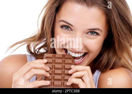 I cant only have one bite. An attractive young woman eating a slab of chocolate Stock Photo