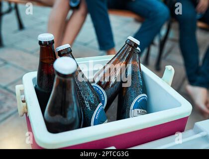Ice cold beers all party long. bottled beers chilling in a cooler box at an outdoor gathering Stock Photo
