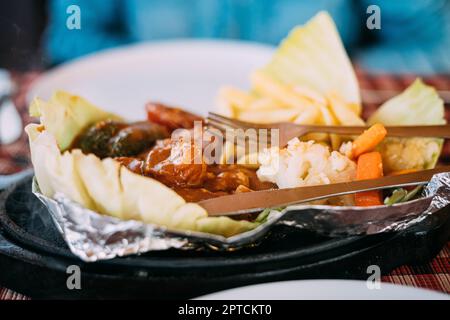 Goa, India. Dish Of Indian National Cuisine Is Sizzler, Which Consist Of French Fries, Fried Shrimp In Sauce, Fried Vegetables. Traditional Dish Of Go Stock Photo