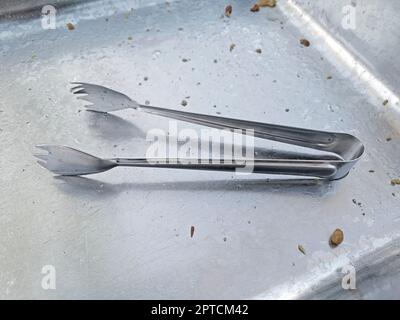 tongs. tongs are a tool for grabbing food, etc Stock Photo