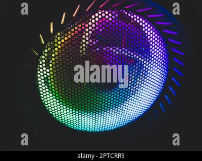 Colorful led lights of computer fan shines through the protective grid. illumination glows in the dark. abstract futuristic background Stock Photo
